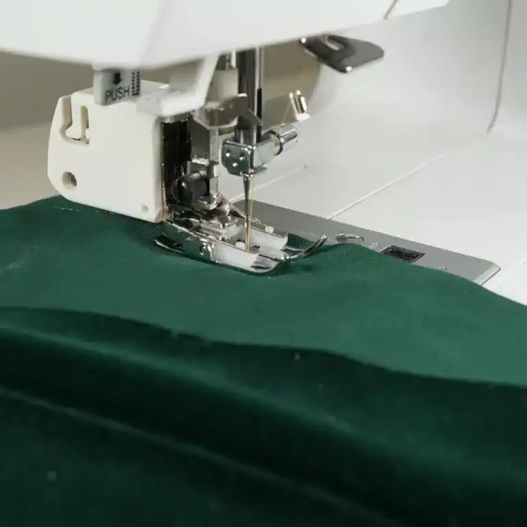 Walking foot attached to a sewing machine, showing the fork-shaped arm positioned over the needle clamp screw.