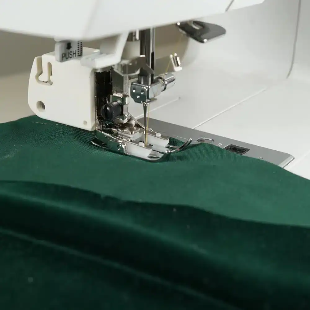 Walking foot attached to a sewing machine, showing the fork-shaped arm positioned over the needle clamp screw.